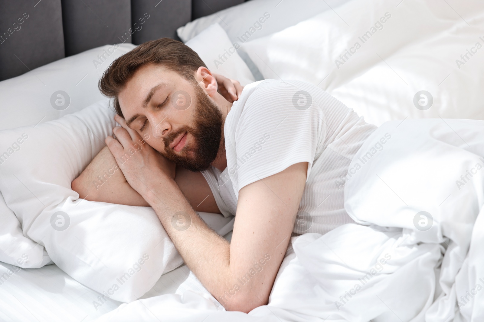 Photo of Handsome young man sleeping in bed at morning