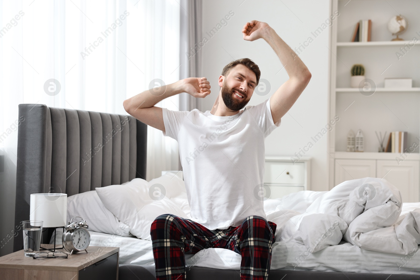 Photo of Young man stretching on bed at morning