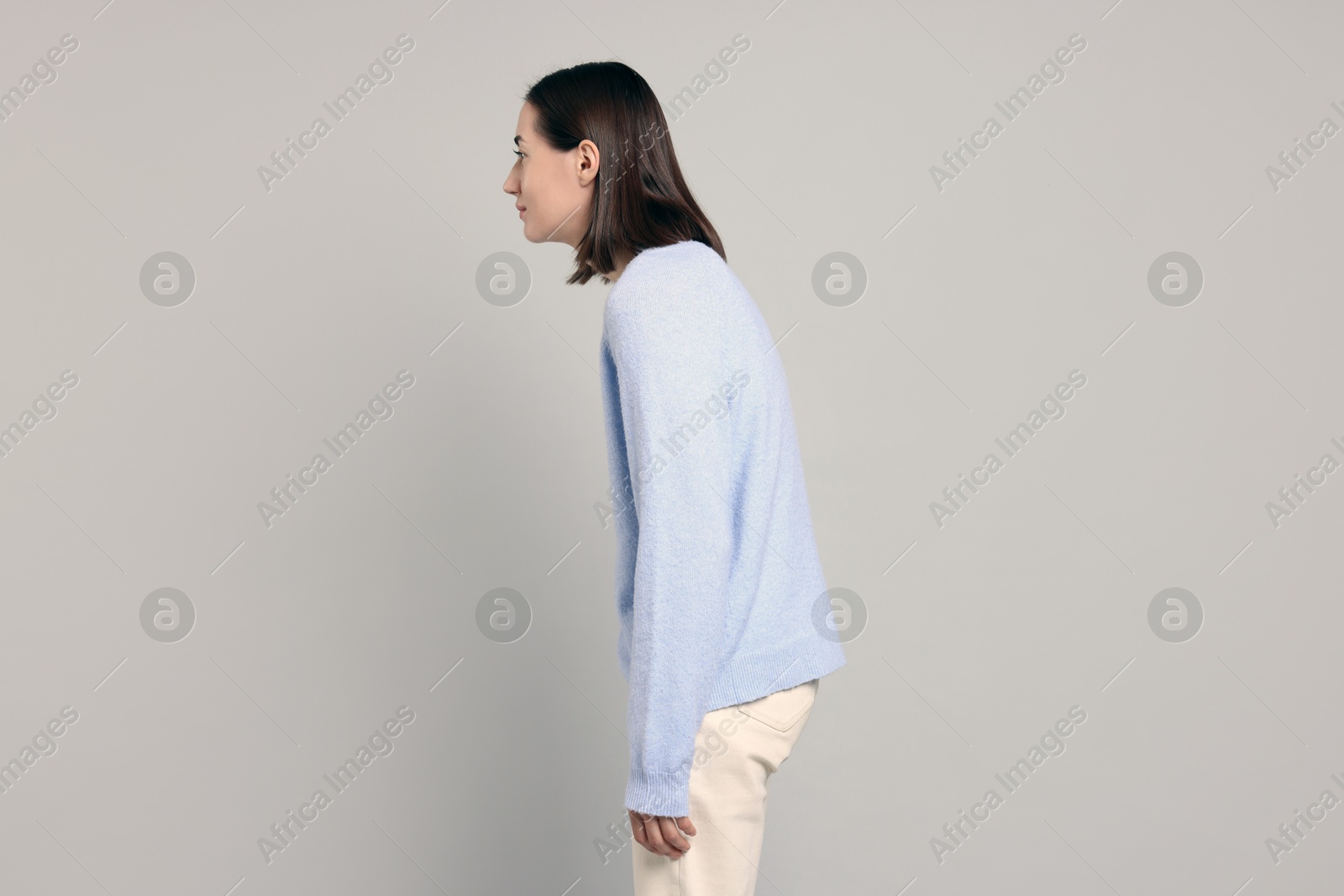 Photo of Woman with poor posture on gray background