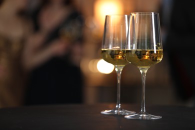 Photo of Tasty wine in glasses on black table indoors, selective focus