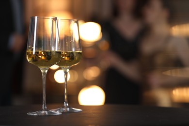 Photo of Tasty wine in glasses on black table indoors, selective focus