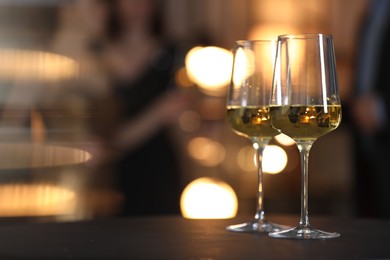 Photo of Tasty wine in glasses on black table indoors, selective focus