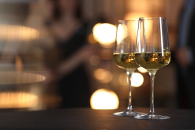 Tasty wine in glasses on black table indoors, selective focus