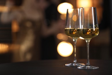 Photo of Tasty wine in glasses on black table indoors, selective focus