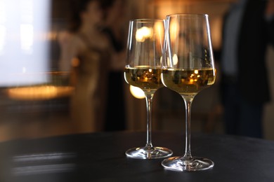 Different tasty wines in glasses on black table indoors, selective focus