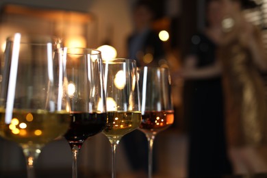 Different tasty wines in glasses indoors, selective focus