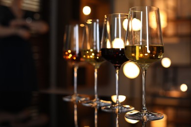 Different tasty wines in glasses on table indoors, selective focus