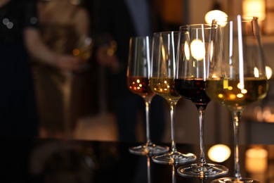 Different tasty wines in glasses on table indoors, selective focus