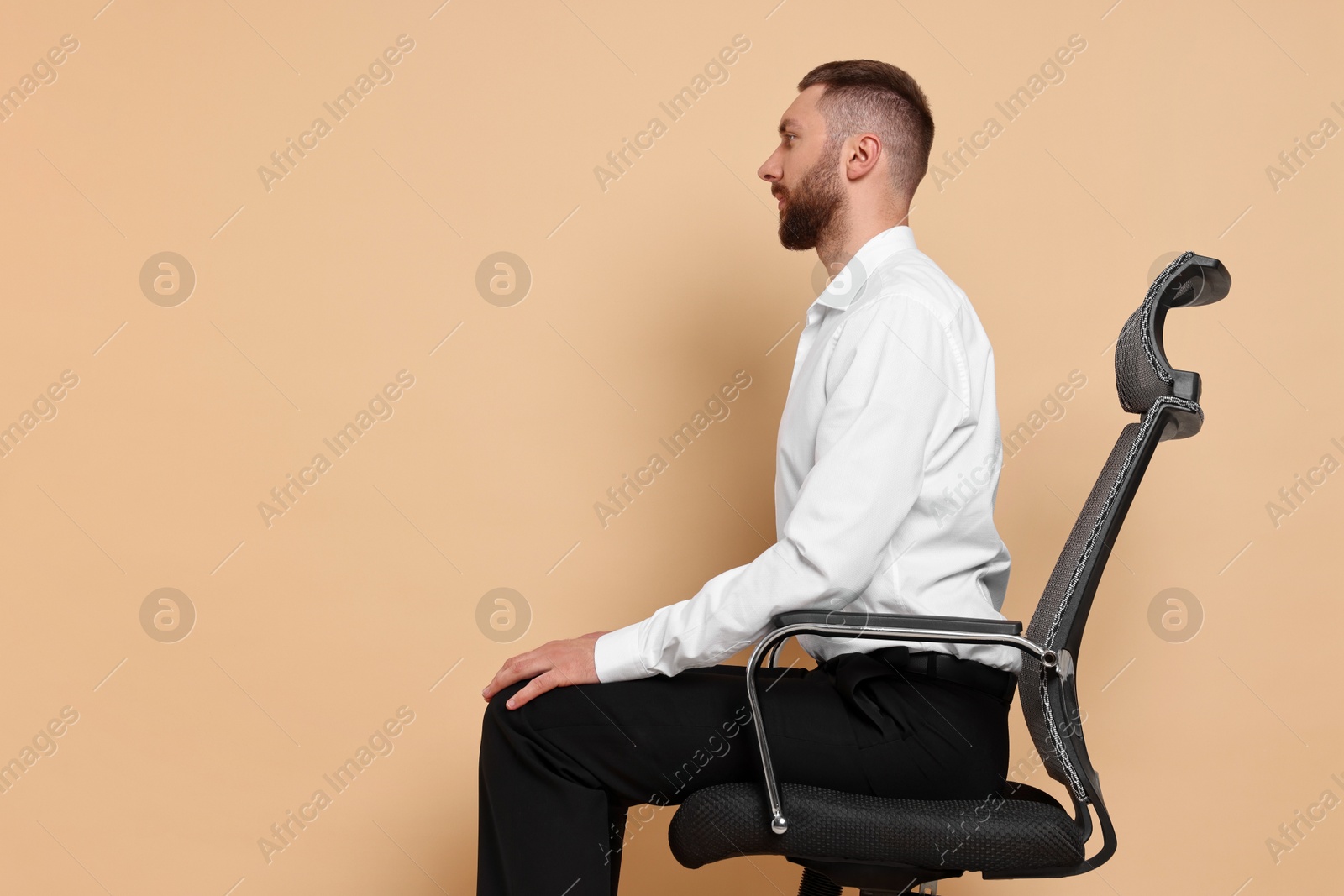 Photo of Man with good posture sitting on chair against pale orange background, space for text