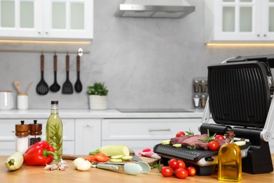 Electric grill and different products on wooden table