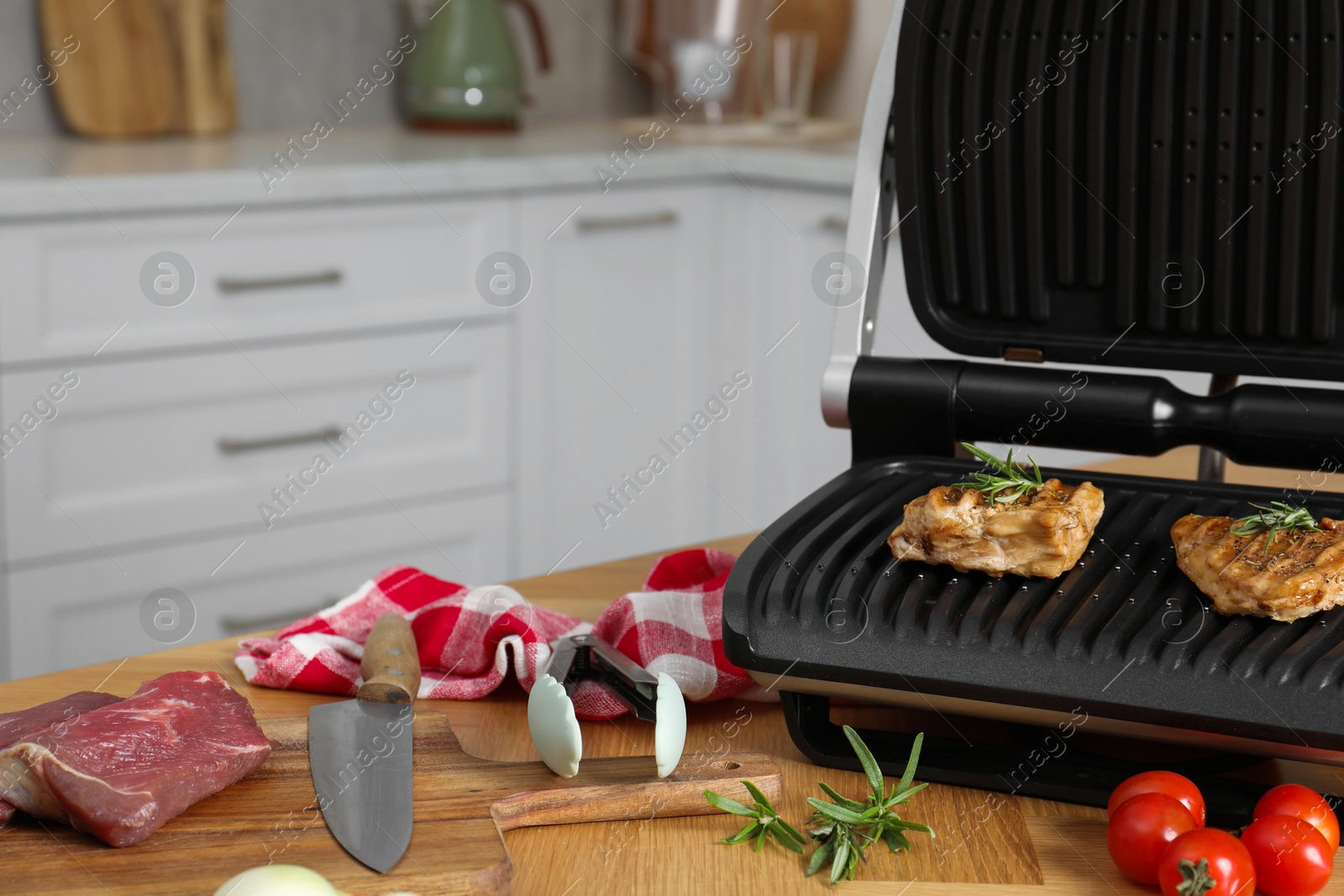 Photo of Electric grill and different products on wooden table