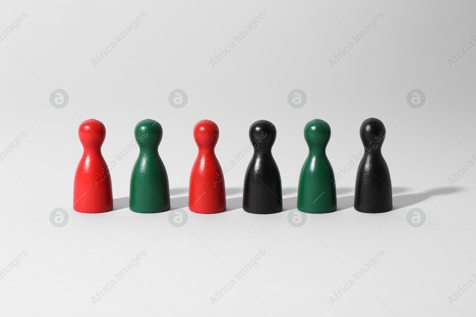 Photo of Equality concept. Different game pieces on light background