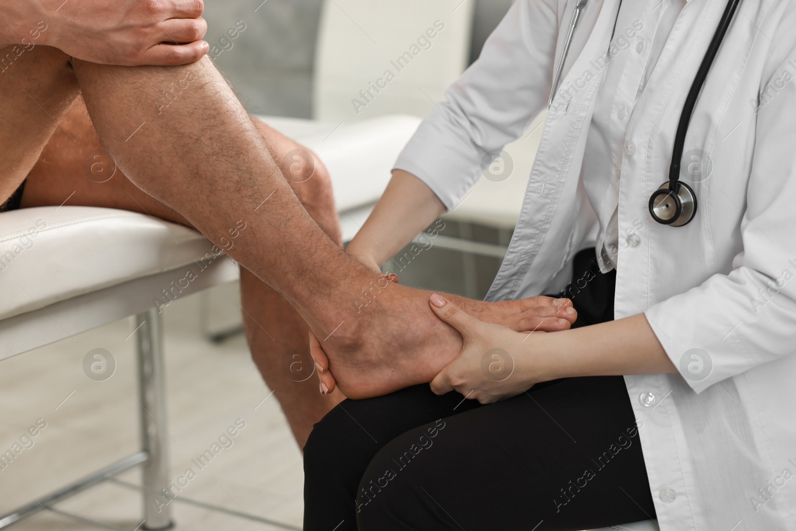 Photo of Sports injury. Doctor examining patient's foot in hospital, closeup