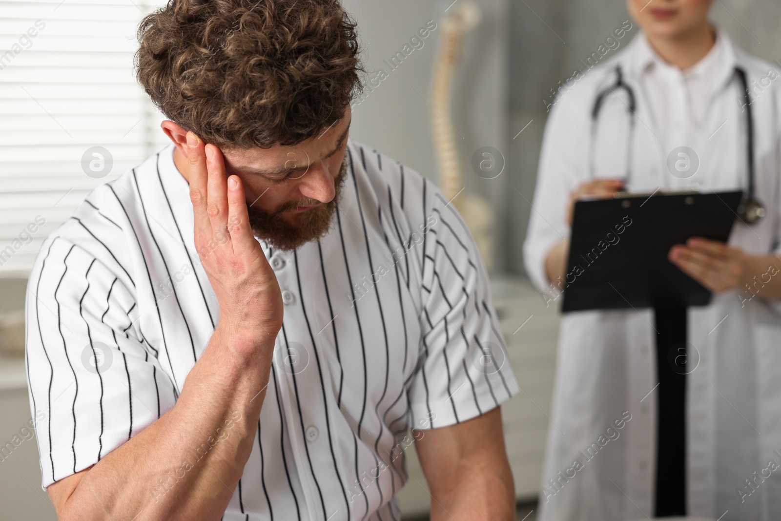 Photo of Injured sportsman and doctor in hospital, selective focus