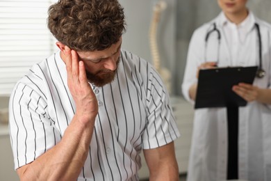 Injured sportsman and doctor in hospital, selective focus