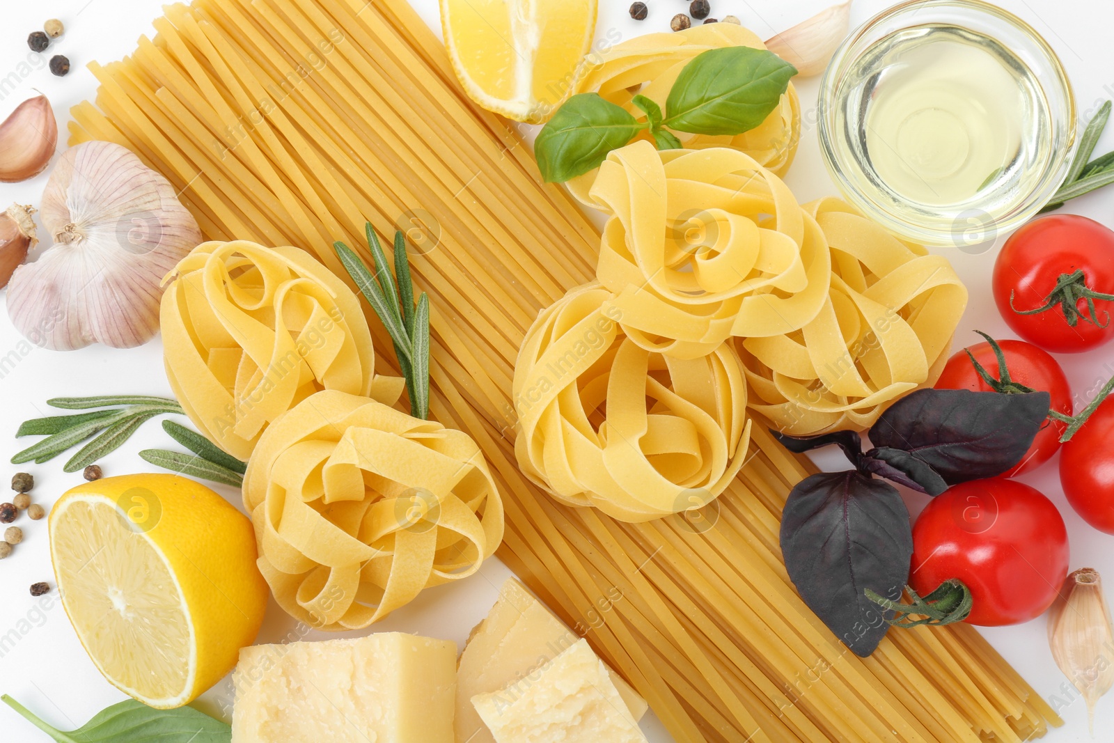 Photo of Different types of pasta and ingredients on white background, flat lay