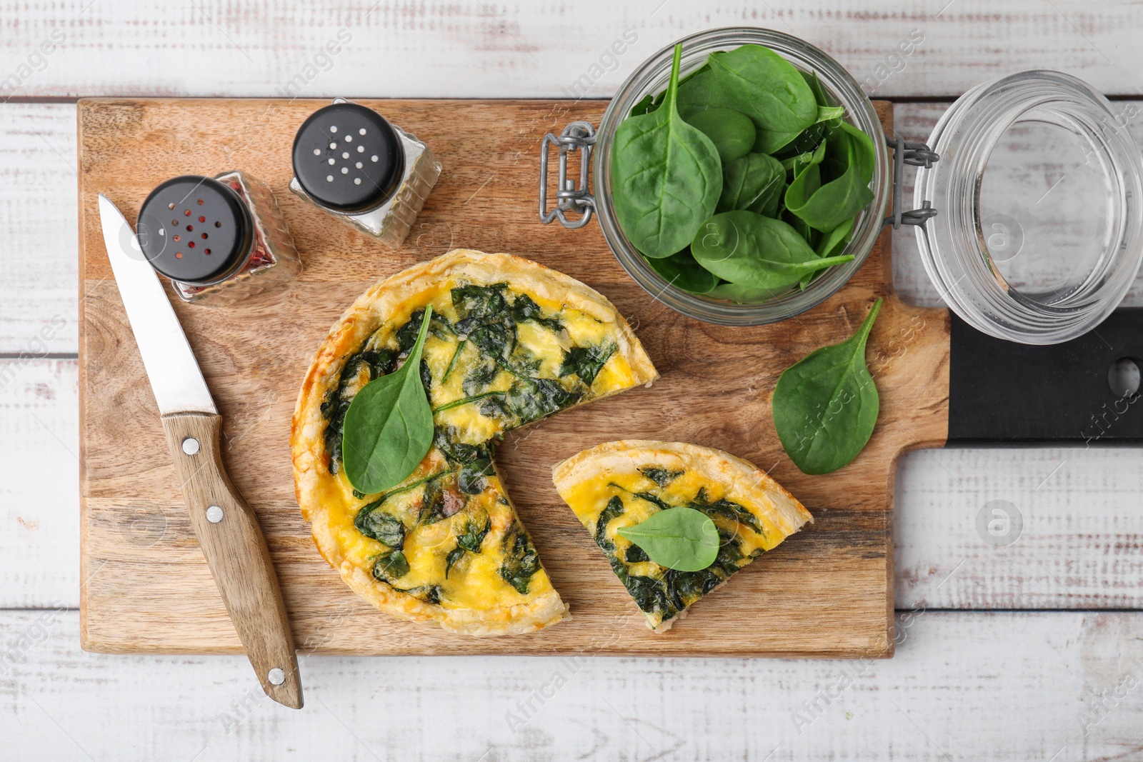 Photo of Delicious cut pie with spinach on white wooden table, top view