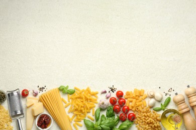 Different types of pasta, grater, spices and products on light table, flat lay. Space for text