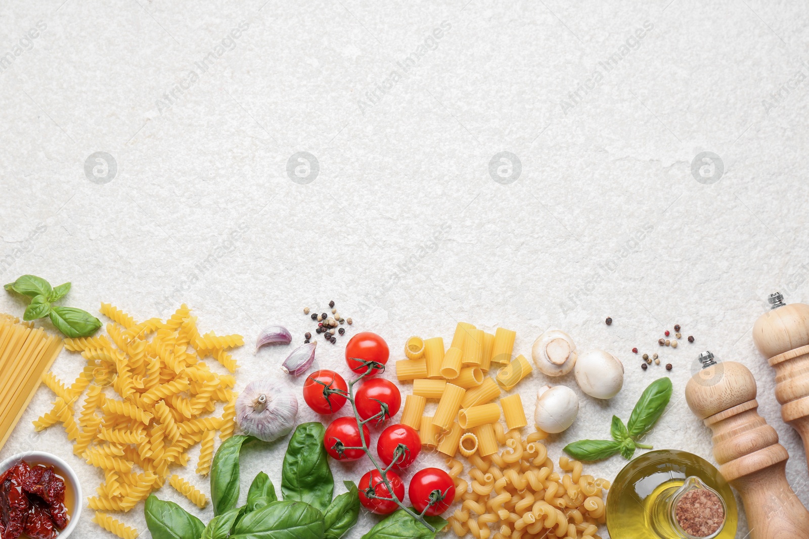 Photo of Different types of pasta, spices and products on light table, flat lay. Space for text