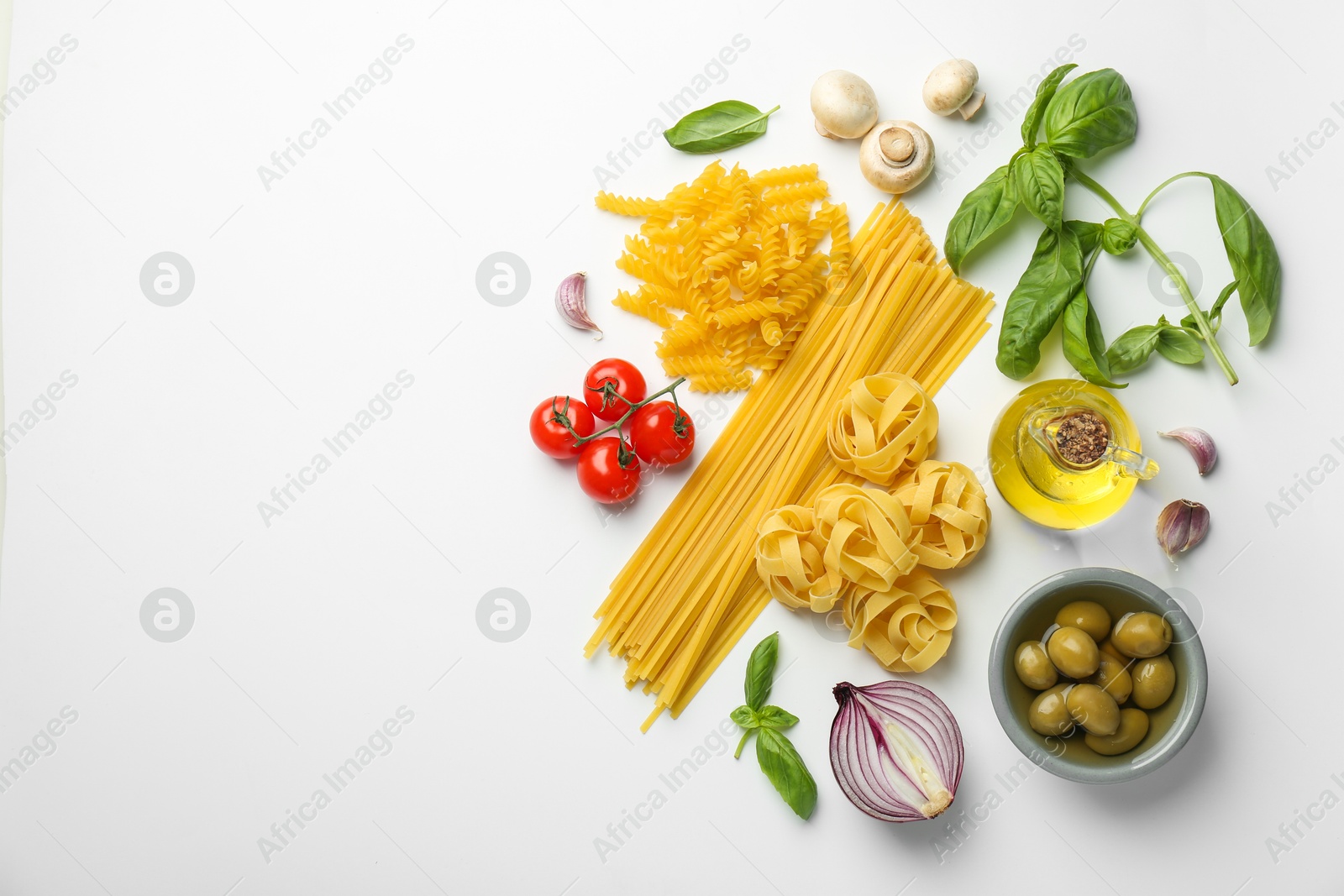 Photo of Different types of pasta, spices and products on white background, top view. Space for text