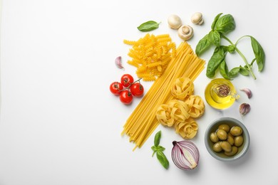 Photo of Different types of pasta, spices and products on white background, top view. Space for text