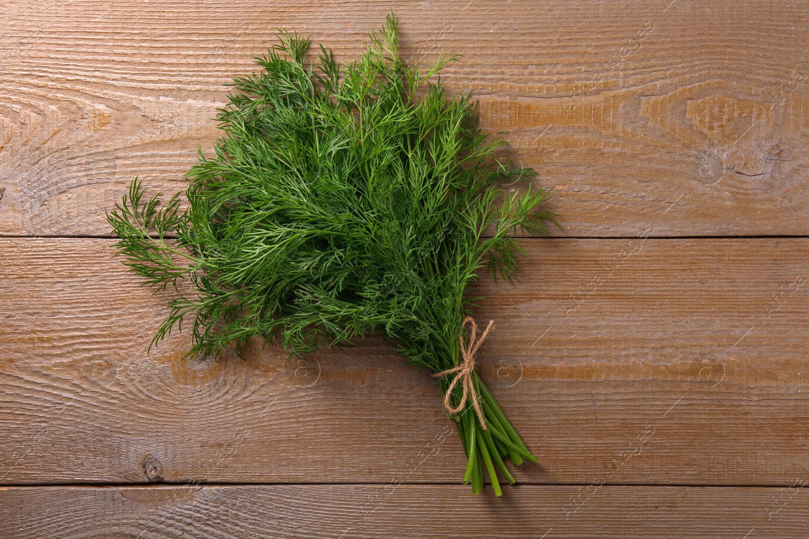 Photo of Bunch of fresh dill on wooden table, top view