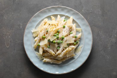 Photo of Delicious pasta with green peas, cheese and creamy sauce on grey table, top view