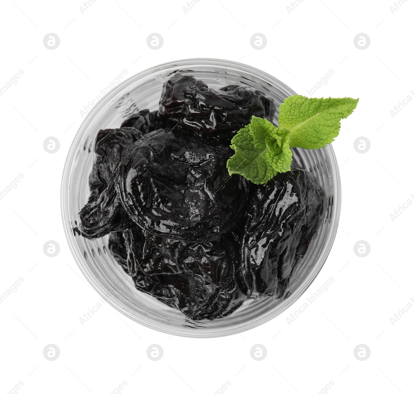 Photo of Tasty dried plums (prunes) in glass bowl and mint leaves isolated on white, top view