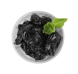 Photo of Tasty dried plums (prunes) in glass bowl and mint leaves isolated on white, top view