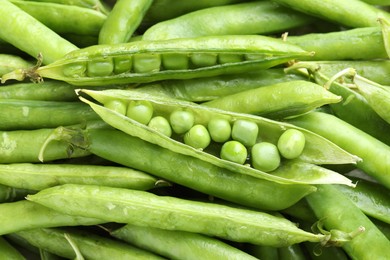 Photo of Many fresh green pods and peas as background, closeup