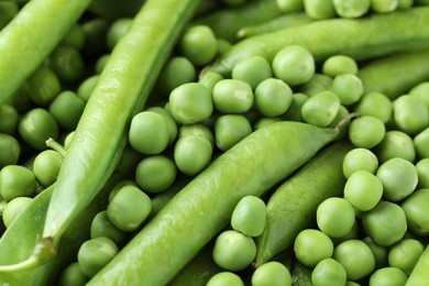 Photo of Many fresh green pods and peas as background, closeup