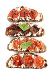 Photo of Delicious ricotta bruschettas with tomatoes, basil and sauce isolated on white, top view