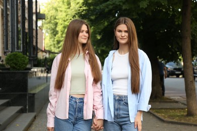 Portrait of two beautiful twin sisters outdoors