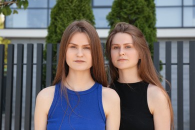 Photo of Two beautiful twin sisters on city street
