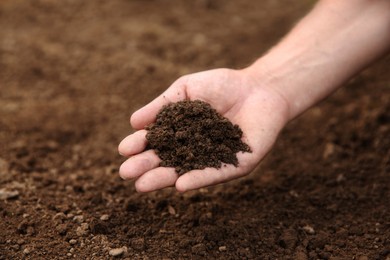 Photo of Woman holding pile of soil outdoors, closeup. Space for text