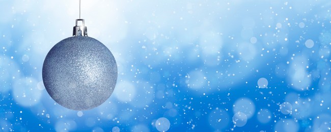 Image of Shiny Christmas ball against blurred background with bokeh effect. Banner design with space for text