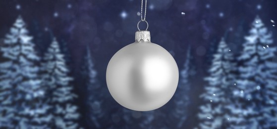 Image of White Christmas balls against snowy forest, banner design