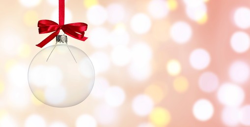 Image of Christmas ball against blurred background with bokeh effect, space for text. Banner design