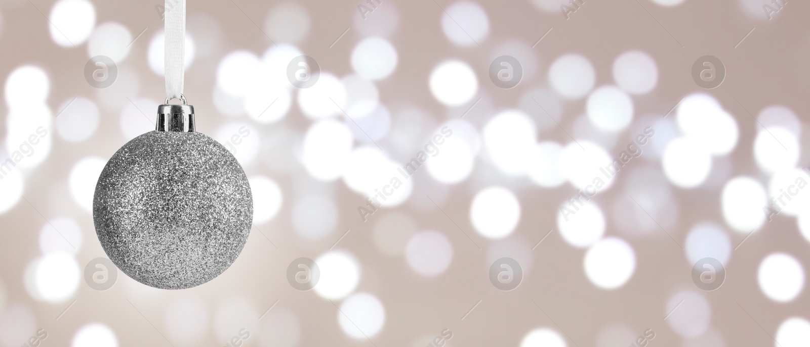 Image of Silver Christmas ball against blurred background with bokeh effect, space for text. Banner design