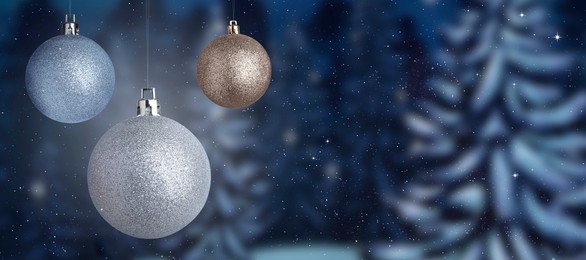 Image of Beautiful Christmas balls against snowy forest, banner design. Space for text