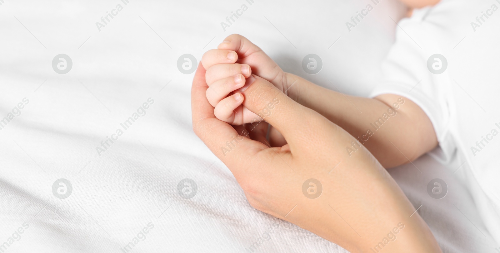 Image of Mother with her small baby on bed, closeup. Banner design with space for text