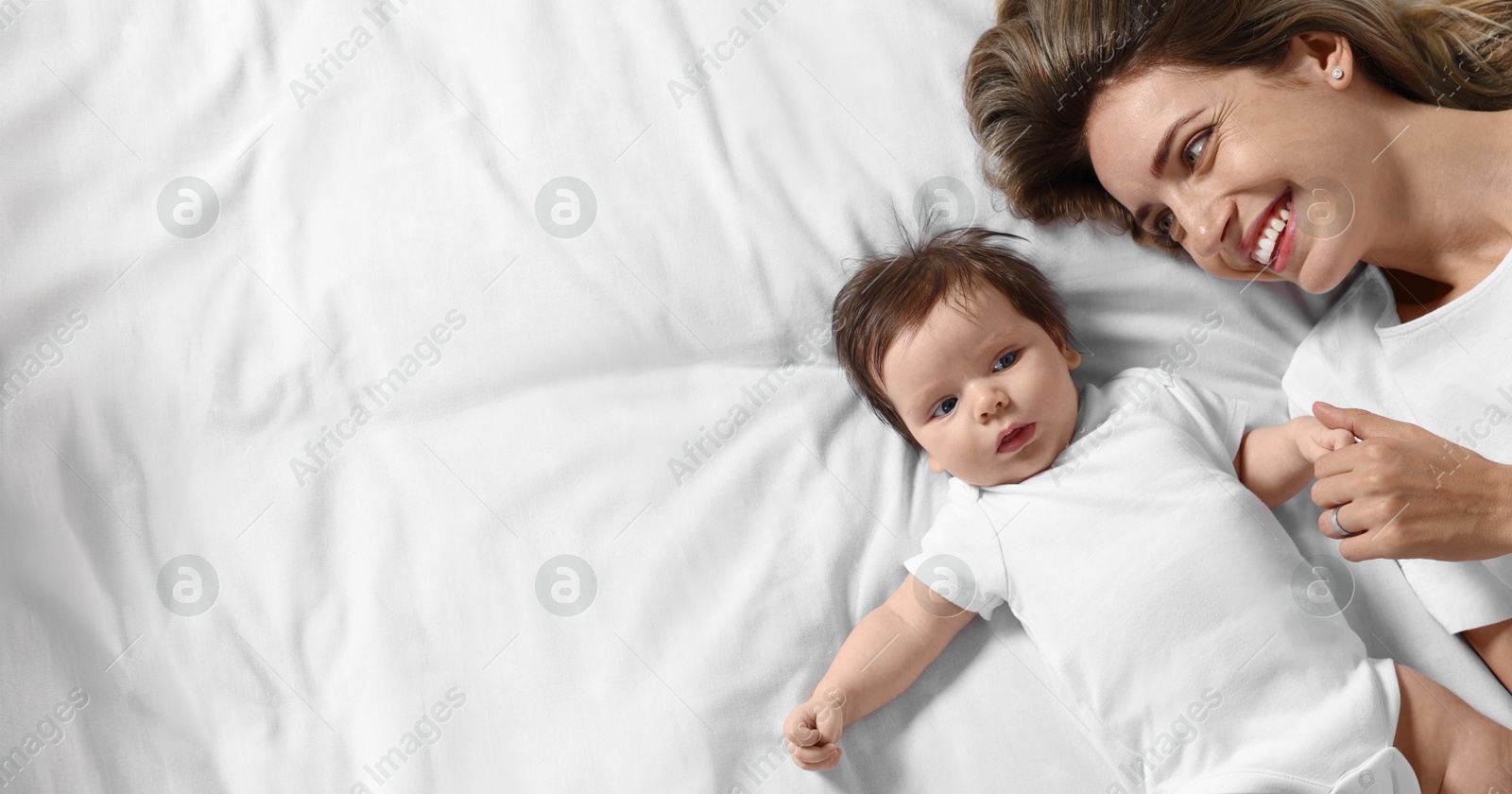 Image of Mother with her small baby on bed, space for text. Banner design