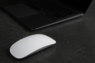 Photo of Wireless mouse on dark textured table, closeup