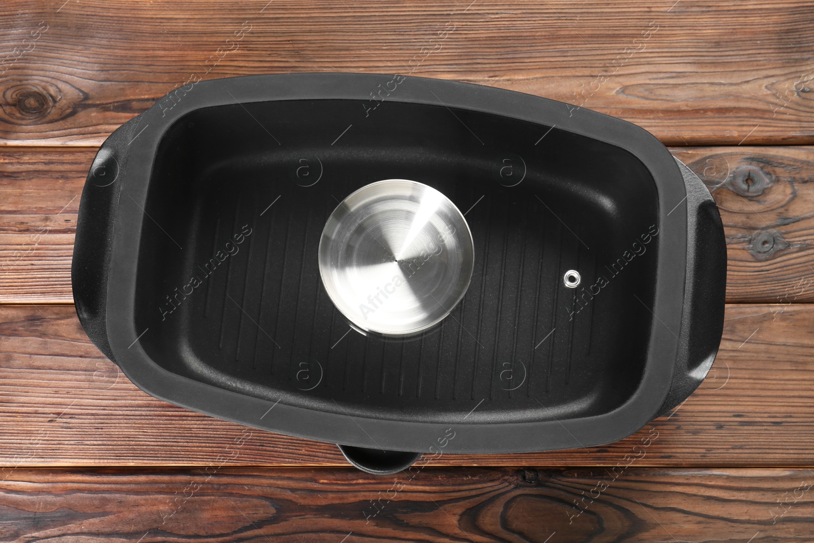 Photo of Black pot with glass lid on wooden table, top view