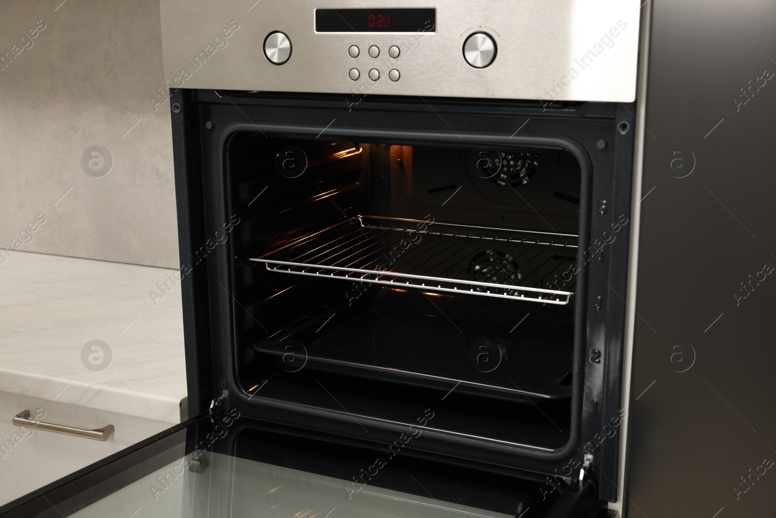 Photo of Open electric oven in kitchen. Cooking appliance