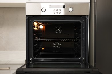 Photo of Open electric oven in kitchen. Cooking appliance