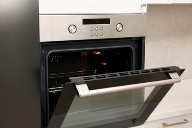 Photo of Open electric oven in kitchen. Cooking appliance