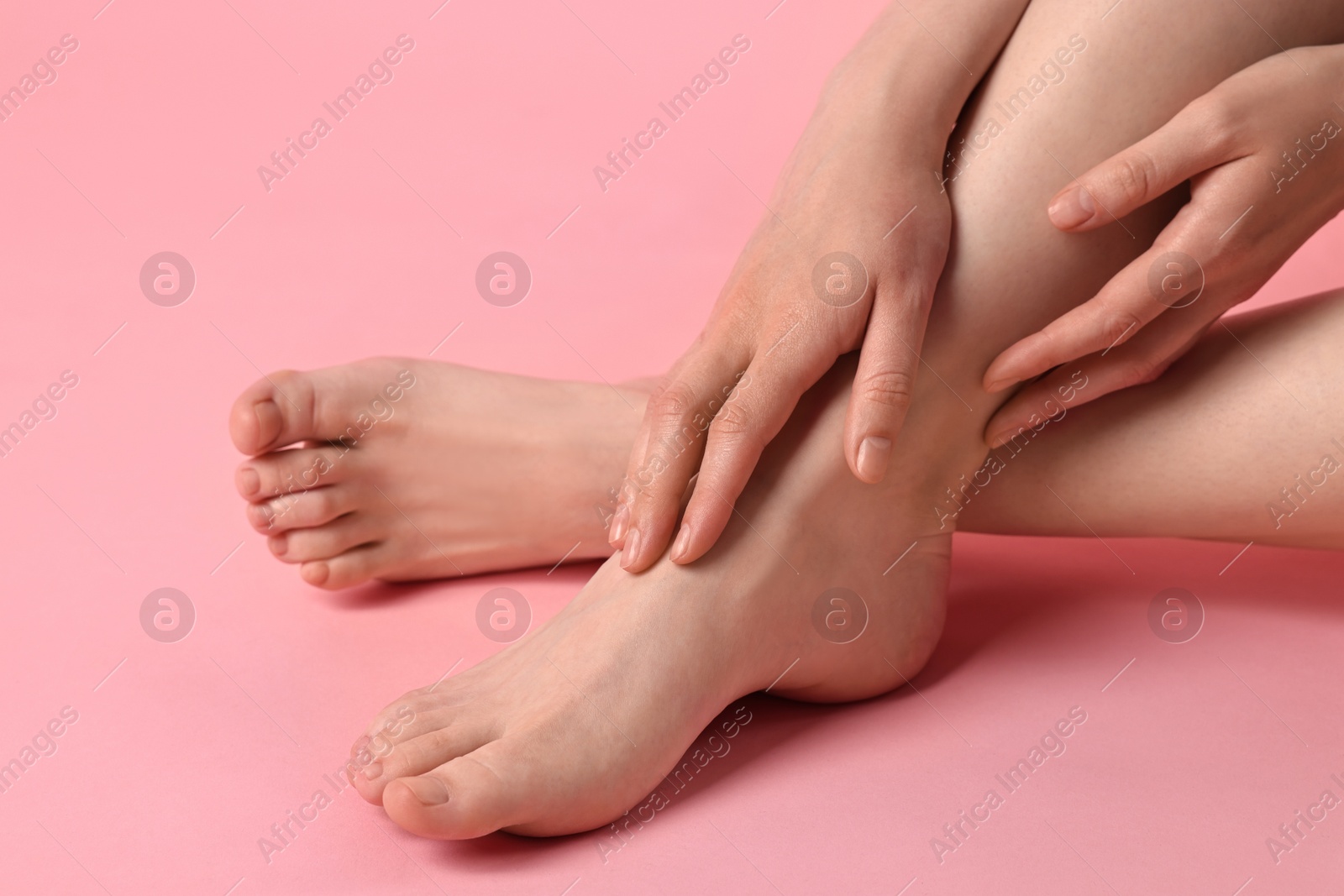 Photo of Closeup view of woman`s groomed feet after care procedure on pink background