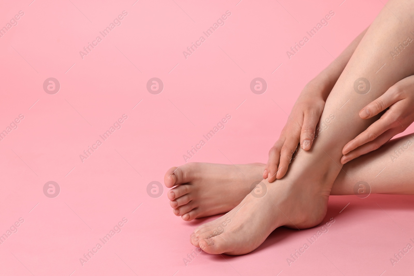 Photo of Closeup view of woman`s groomed feet after care procedure on pink background. Space for text