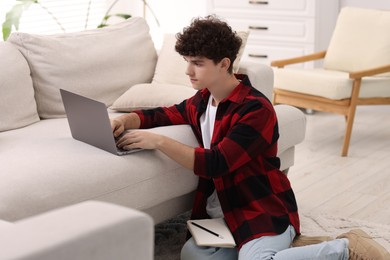 Photo of Teenager working with laptop at home. Remote job
